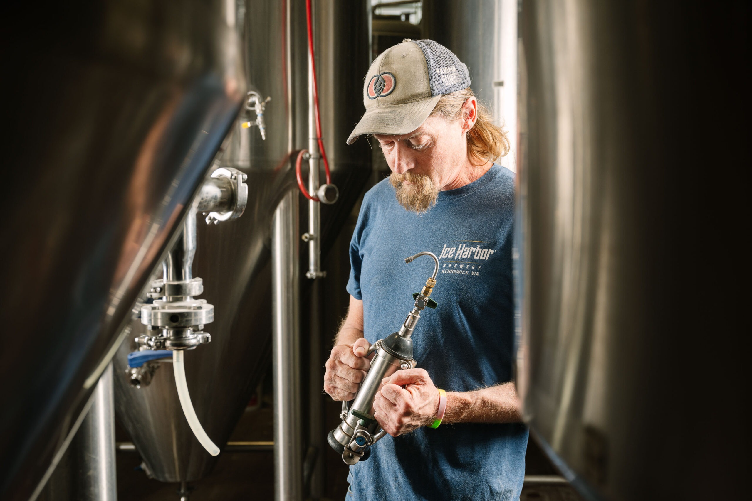 Ice Harbor brewer handling brewing equipment in the Kennewick brewhouse